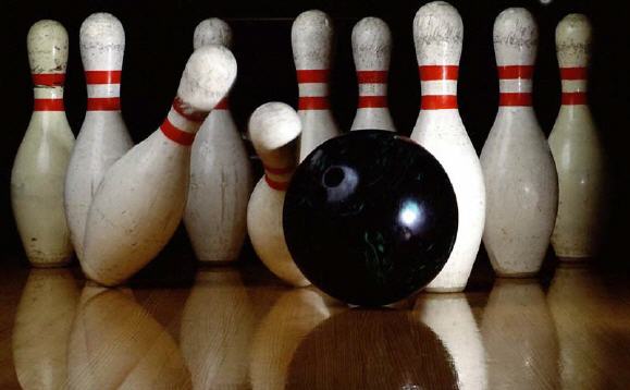 Photo of a red bowling ball hitting the pins in the 1-3 pocket.